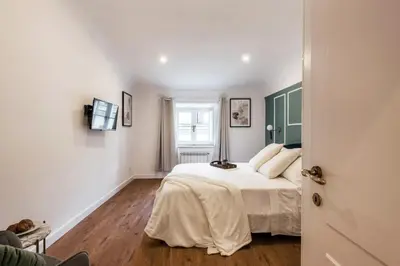 a bedroom with a bed with white sheets and a window at The Best Rent - Refined multi-room apartment in Termini area in Rome