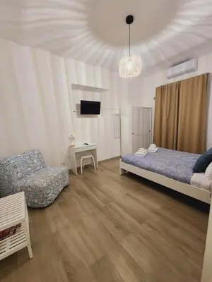 a bedroom with a bed and a chair and a tv at La Casa di Teo in Rome