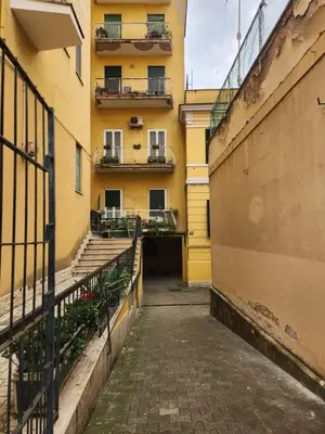 an empty alley with a yellow building and stairs at La Casa di Teo in Rome