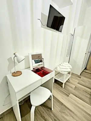 a white desk with a chair and a tv in a room at La Casa di Teo in Rome
