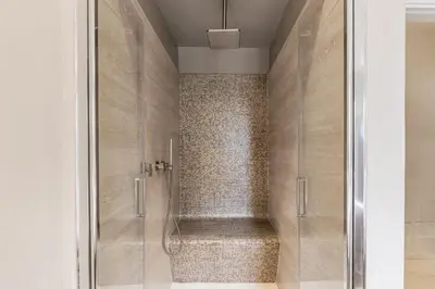 a shower with a glass door in a bathroom at Trastevere Travertino Suite in Rome
