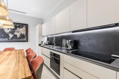 a kitchen with white cabinets and a wooden table at Trastevere Travertino Suite in Rome