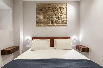 a bedroom with a large bed with two night stands at Trastevere Travertino Suite in Rome