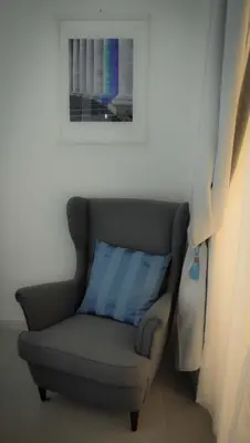 a gray chair with a blue pillow in a room at Rome Together Guest House in Rome