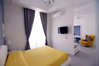 a bedroom with a yellow bed and a yellow chair at Rome Together Guest House in Rome