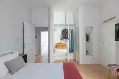 a white bedroom with a bed and a dressing room at iFlat La Dolce Vita - Contemporary Luxury in Rome in Rome
