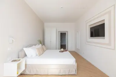 a white bedroom with a white bed and a tv at iFlat La Dolce Vita - Contemporary Luxury in Rome in Rome