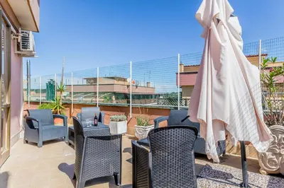 a patio with chairs and a table and an umbrella at NEW OPENING Free Netflix BIG APT Pamphili House in Rome