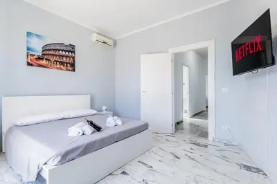 a white bedroom with a bed and a tv at NEW OPENING Free Netflix BIG APT Pamphili House in Rome