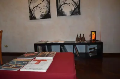 a room with a table with books and a table with shoes at St Peter view House Vatican in Rome