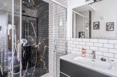 a bathroom with a glass shower and a sink at AMORE MIO - Art House in Rome