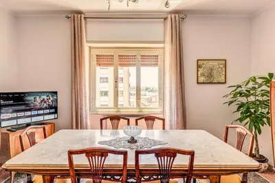 a dining room with a table and chairs and a window at AMORE MIO - Art House in Rome