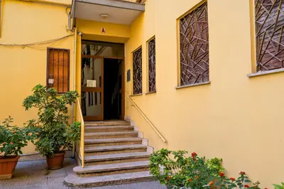 a yellow house with stairs leading to the door at AMORE MIO - Art House in Rome