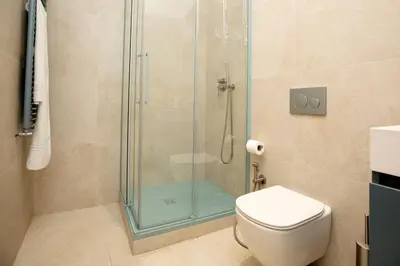 a bathroom with a glass shower with a toilet at Relais Rosselli in Rome