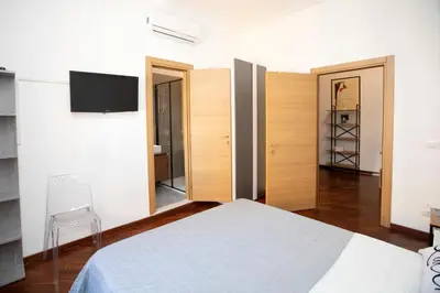 a bedroom with a bed and a tv on the wall at Relais Rosselli in Rome