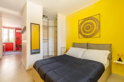 a bedroom with a bed with a yellow wall at Urban Loft Piramide in Rome