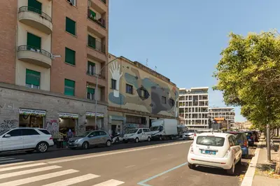 a city street with cars parked in front of a building at Urban Loft Piramide in Rome