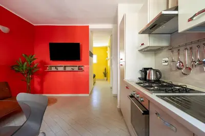 a kitchen with a red wall with a tv on it at Urban Loft Piramide in Rome