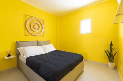 a bedroom with a bed with yellow walls at Urban Loft Piramide in Rome