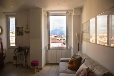 a living room with a couch and a large window at Via Rocca House in Rome