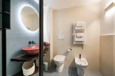 a bathroom with a sink and a toilet and a mirror at Elegant Apartment Minelli Navona by GHOR in Rome