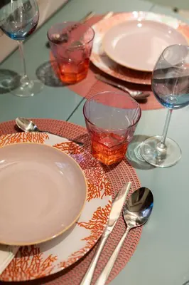 a table with plates and wine glasses and utensils at Elegant Apartment Minelli Navona by GHOR in Rome