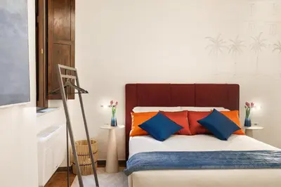 a bedroom with a bed with orange and blue pillows at Elegant Apartment Minelli Navona by GHOR in Rome