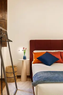 a bedroom with a bed with orange and blue pillows at Elegant Apartment Minelli Navona by GHOR in Rome