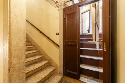 a hallway with stairs and a wooden door at Elegant Apartment Minelli Navona by GHOR in Rome
