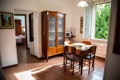 a dining room with a table and chairs and a kitchen at La Casa di SilvAnna in Rome