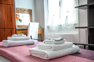 three towels are stacked on top of a table at La Casa di SilvAnna in Rome