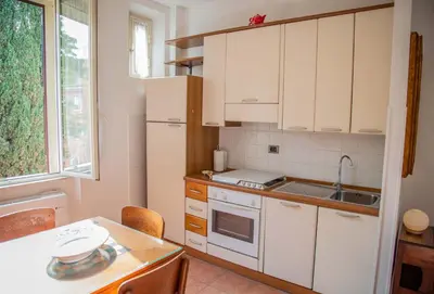 a kitchen with white cabinets and a sink and a table at La Casa di SilvAnna in Rome