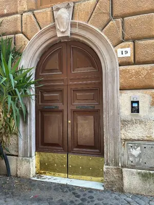 a large wooden door on the side of a building at La Casa di SilvAnna in Rome