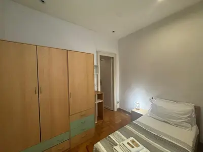 a bedroom with a bed and a wooden cabinet at Spacious Getaway with Roman Charm in Rome