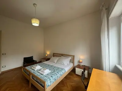 a bedroom with a bed and a desk and a lamp at Spacious Getaway with Roman Charm in Rome