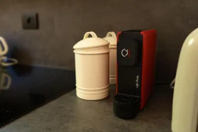 two coffee cups sitting on a counter next to a coffeemaker at Casa di NOAH in Rome