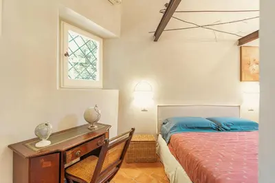 a bedroom with a bed and a desk and a window at Casa di NOAH in Rome