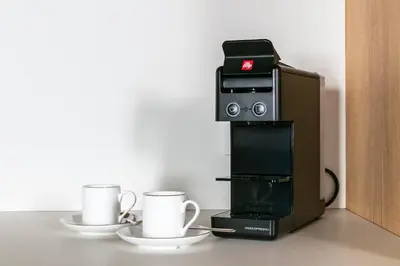 a coffee machine with two cups on a table at Design Suite apartment Piazza di Spagna in Rome