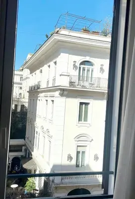 a large white building is seen through a window at Design Suite apartment Piazza di Spagna in Rome