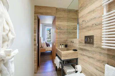a bathroom with a sink and a wooden wall at Design Suite apartment Piazza di Spagna in Rome