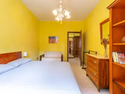 a bedroom with a bed and a yellow wall at Casa Lo Vercio in Rome