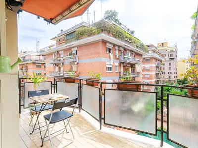 a balcony with a table and chairs and a building at Casa Lo Vercio in Rome