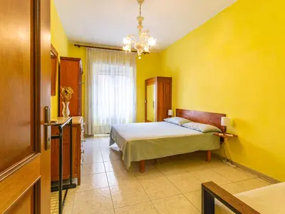 a bedroom with a bed and a yellow wall at Casa Lo Vercio in Rome