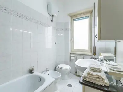 a white bathroom with a tub and a toilet and a sink at Casa Lo Vercio in Rome