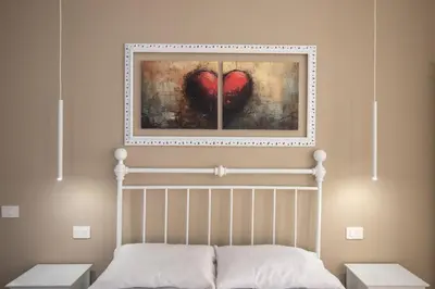 a bedroom with a bed with a painting of a heart at PapaRoma Suite in Rome
