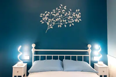 a bedroom with a blue wall with a tree sticker on the wall at PapaRoma Suite in Rome