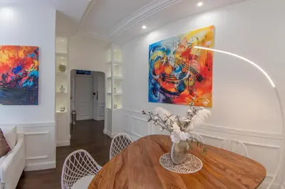a dining room with a table and paintings on the wall at PapaRoma Suite in Rome