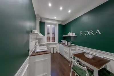 a salon with green walls and a table and chairs at PapaRoma Suite in Rome