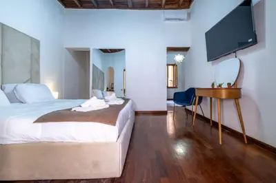 a bedroom with a bed and a flat screen tv at Trevi Guesthouse in Rome