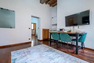 a living room with a table and chairs and a television at Trevi Guesthouse in Rome